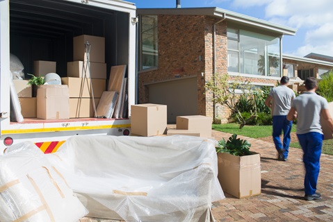 men moving boxes into a house