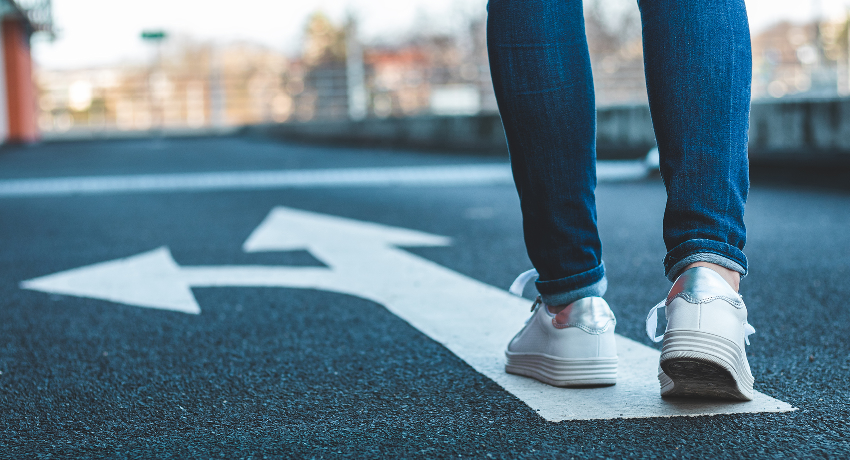 person walking along street with arrow