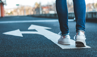 person walking along street with arrow